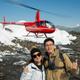 Helicopter parked on a glacier as passengers explore during an Alaskan tour.