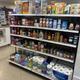 A well-stocked convenience store shelf with groceries and toiletries.