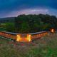 Wide dusk/evening view of multiple cabin units with warm interior lighting — demonstrates the arrangement of units and ambiance after dark (gallery image on the property site).