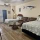 Interior of a furnished cabin showing beds, kitchenette and coastal decor — demonstrates cabin accommodation offered on-site (matches cabins description on the site).