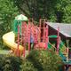 Playground equipment (slides, climbing) and a picnic shelter visible in a landscaped area — from the Facilities page, demonstrates family/recreation facilities on site.