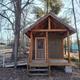 Small rustic cabin exterior (front porch and ramp) showing cabin lodging option on the grounds.