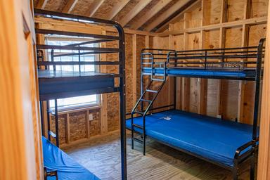 Interior shot of a cabin bunk room with multiple beds — useful to illustrate cabin sleeping arrangements and interior amenities (from cabin rentals photos).