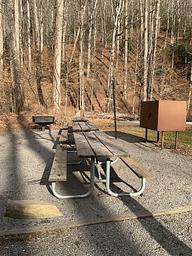 Three picnic tables with bear box and cooking grill for group dining.
