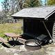 Shelter, picnic table and fire ring in forest and grass setting