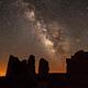 Ancient structures silhouetted against the night sky and the Milky Way
