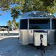 External view of an Airstream travel trailer parked under a tree at Big Pine Key RV Park in Florida