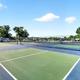 Outdoor photo of the tennis/pickleball courts with RV sites visible in the background — highlights recreational facilities on the property; included on the amenities page.