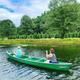 Two people paddling a green canoe on the property’s lake/pond, showing on‑site water recreation and shoreline vegetation (page: Starlite Lodge).