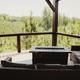 Overlook deck view showing furnished seating and forested vista — emphasizes scenic overlooks and private deck amenities that visitors would use at the retreat.