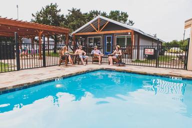 Pool area with fenced pool, lounging guests and adjacent buildings — illustrates onsite pool and social facilities, from the Mystic Quarry gallery.