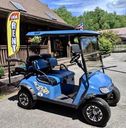 Photo of the campground’s rental golf cart parked in front of the store/office building — illustrates on-site amenities and the camp store area (from Amenities page).