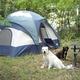 Ground-level campsite with a pitched tent, picnic table, and a dog — clear photo of tent camping area on the property; matches header images on the site showing on-site tent sites and wooded setting.