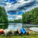 Wide scenic view of Calef Lake with canoes on the shore — strong overview of the campground's lakefront amenity (used as a background on the home page).