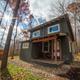 Another exterior cabin shot with surrounding trees and sunlight; offers a different angle and scale of on-site lodging for a varied gallery.