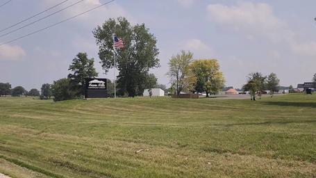 Entrance/grounds view with Haven Hills sign, open lawn and buildings in background — useful overall site/landscape overview.