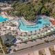 Aerial overview of the property waterpark and surrounding grounds — clear bird’s-eye view showing pool complex layout, nearby parking and buildings (matches site waterpark/gallery context). Source page: Home - Ocean Lakes Family Campground.