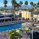 Panoramic view of the resort pool and adjacent buildings and seating — clear photo of primary on-site amenity used on the property website.