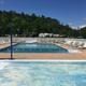 Clear, high-resolution photo of the campground pool with surrounding deck, lounge chairs and RVs visible in the background — shows an important on-site facility (source: Facilities page gallery).