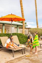 Pool-side scene with lounge chairs, umbrella and palm trees — depicts the campground’s pool/recreation area and on-site amenities (from the campground waystostay photos).