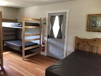 Bedroom is furnished with two sets of bunkbeds and one double bed. 