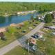 Aerial/drone view showing the campground layout: lakeside beach, RV sites, roads and facilities — comes from the property’s Gallery page (evidence of on-site aerial photo).