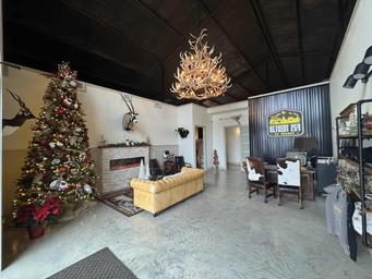 Interior clubhouse/lounge photo (antler chandelier, seating, branded sign) — shows indoor guest spaces and clubhouse character from the property's gallery.