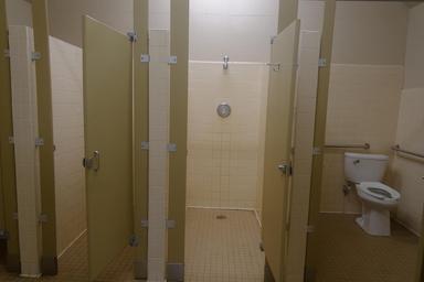 A unit bathhouse interior, showing showers and toilet.