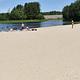 A group of visitors enjoying the Elm Brook Park beach on a clear summer day.