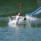 Close-up action shot of a waterslide entry into the lake with swimmers — highlights active water attractions available to guests (sourced from the Lake Park images).