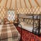 Inside a Roamstead yurt showing twin bunk beds and cozy mountain decor for families.