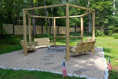 Firepit area with swinging benches and pergola-style frame — shows a communal amenity on the campground grounds (matches bonfire/amenity images on the site).