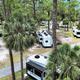 Aerial overview of the RV park showing multiple RV sites, roads and mature palms — useful for overall property layout. Source page is the property listing for Suncoast RV Resort.