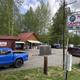 Clear view of campground entrance/office area with sign reading 'Montana Creek Campground', parked vehicles, and campground buildings — establishes on-site services and arrival area (from FAQs page context).