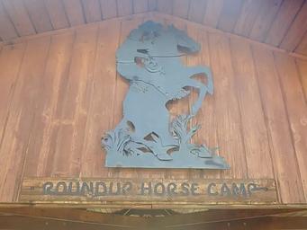 A metal sculpture depicting  a cowboy on a bucking bronco at Roundup Horse Camp