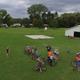 Aerial/drone view over open grassy area with RVs, pavilion/basketball pad and groups of people — useful overall site overview; hosted on main site (home page) showing park grounds.