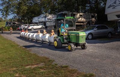 Small train/tractor ride passing by RV sites — illustrates family activities and RV pitch area visible in the background (gallery/original image on the property site).
