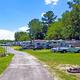 Ground-level view down a paved interior road with RVs and trailers on both sides — good depiction of typical RV pitches and internal roads. (sourced from the property site).