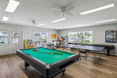 Indoor game room with pool table, ping-pong and large windows overlooking the grounds — demonstrates on-site recreation facilities in the gallery.