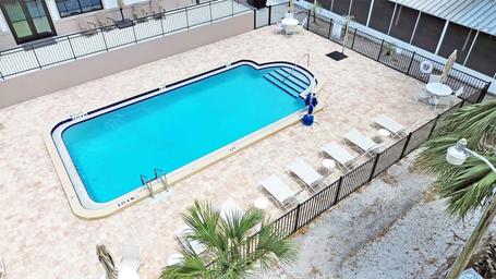 Overhead/angled photo of the resort pool and deck area, showing pool shape, seating and fencing — documents on-site recreation amenity.