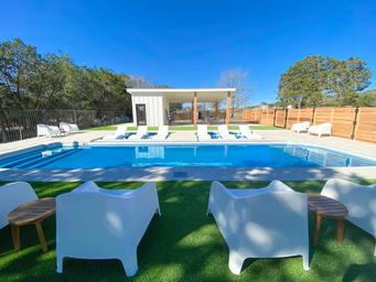 Clear photo of the on-site swimming pool area with lounge chairs, fencing and a pool house — shows guest amenity and layout (page context: Photo Gallery pool image).