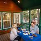Cabin/porch dining shot showing a cabin porch with table and view of the park in background — useful to illustrate cabin accommodations and surroundings.