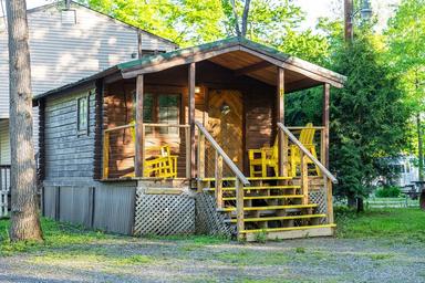 Cabin exterior with porch and seating — shows the campground's cabin lodging option and site surroundings.