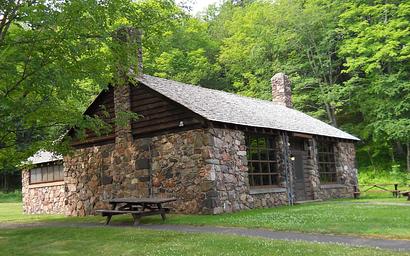 View of the northeast side of the Black River Harbor Pavilion and a couple of picnic tables outside.