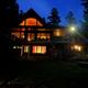 Exterior night view of the main lodge/building on the property with lit windows and surrounding trees — good overall impression of the facility (from the property gallery page).
