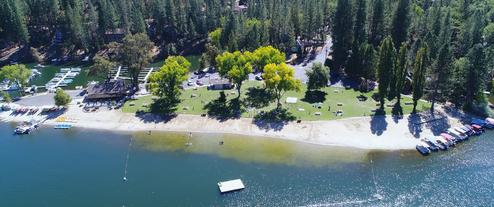 Aerial/shoreline photo of the lake beach, docks and marina area — strong property overview of Pine Mountain Lake from the main site (useful scenic view and public beach/marina facility).