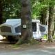 Another numbered campsite (site #7) with a pop-up camper and wooded surroundings — useful to show camping accommodations and site spacing.
