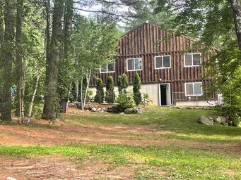 Lodge/office building set among trees on the property — useful to show on‑site buildings and wooded setting (appears in site Contact/Info pages).