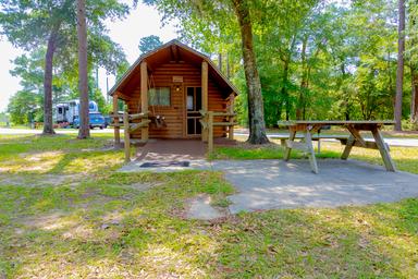 Small standalone cabin with porch and picnic table in a wooded setting — represents rental cabin accommodations on the property (source: site homepage).