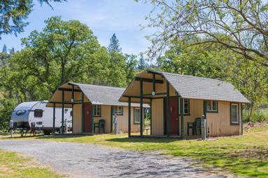 Small cottage/cabin units with an RV in background — shows lodging options and campsite adjacency (site/gallery imagery).